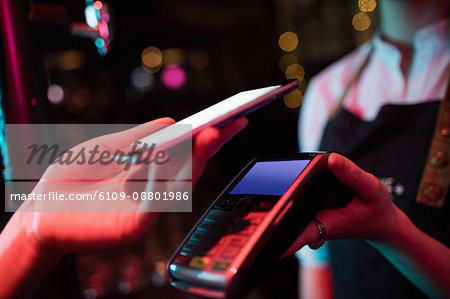Customer making payment through smart phone in bar
