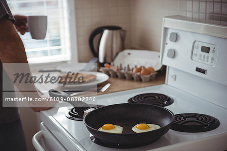 Fried eggs in a frying pan at kitchen at home