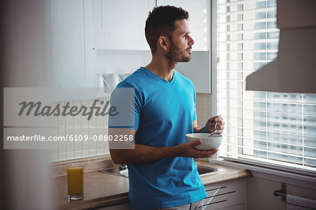Man having breakfast in the kitchen at home