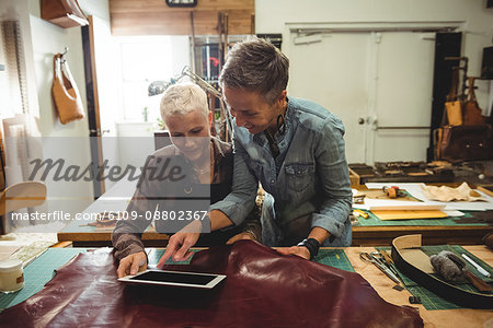 Craftswomen using digital tablet in workshop