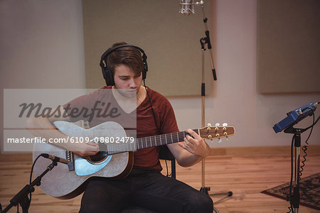 Man playing a guitar in music studio