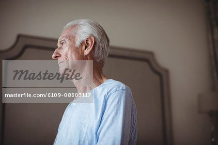 Thoughtful senior man in bedroom at home