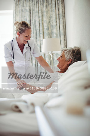 Female doctor interacting with senior patient at home