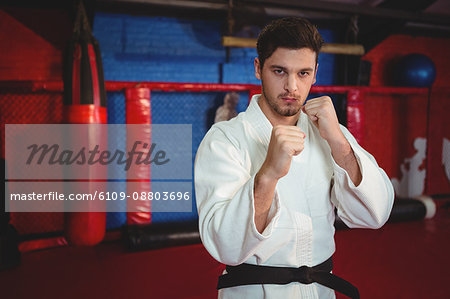 Karate player performing karate stance in fitness studio