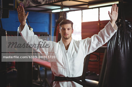 Karate player standing with arms spread in fitness studio