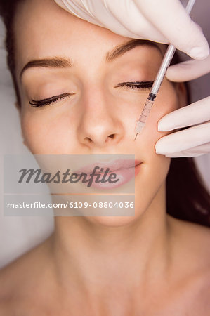 Female patient receiving an injection on her face in clinic