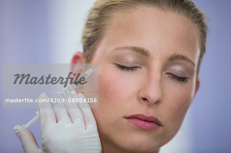 Close-up of female patient receiving a botox injection on face