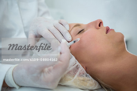 Close-up of female patient receiving a botox injection on face