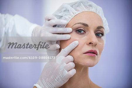 Close-up of doctor examining female patients face for cosmetic treatment