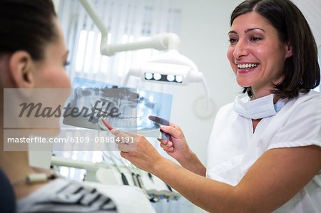 Dentist showing x-ray to her patient in dental clinic