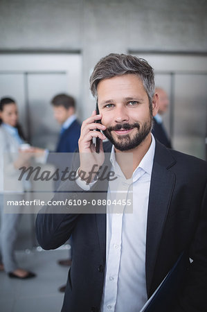 Businessman talking on mobile phone in office