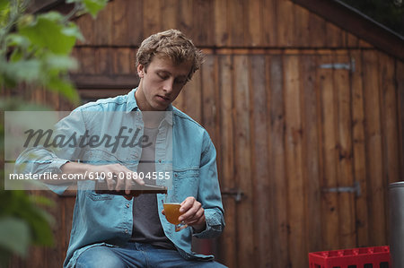 Man sitting at home brewery pouring beer into a beer glass