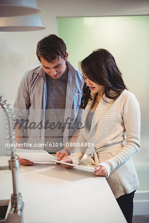 Couple discussing over digital tablet in kitchen at home
