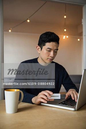 Man doing online shopping on laptop at home