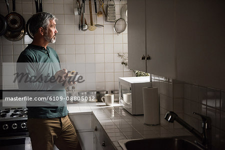 Thoughtful man having breakfast in kitchen at home