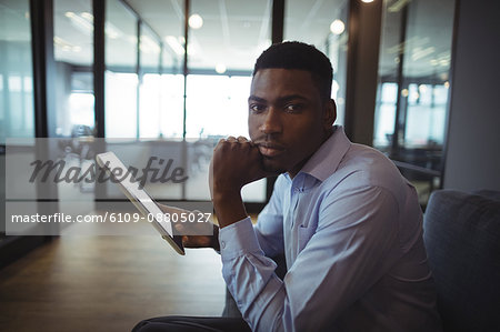 Portrait of businessman holding digital tablet in office