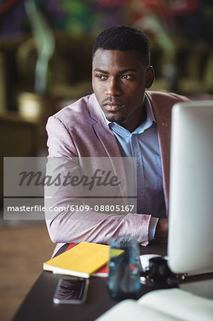 Thoughtful businessman looking away in office