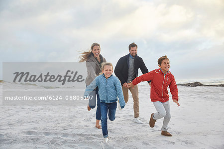 Playful family running on winter beach