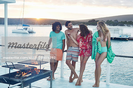 Young adult friends hanging out and drinking on summer houseboat