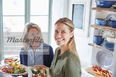 Portrait smiling mother and daughter serving food