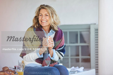 Enthusiastic senior woman drinking coffee on patio