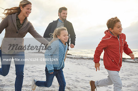 Playful family running on winter beach