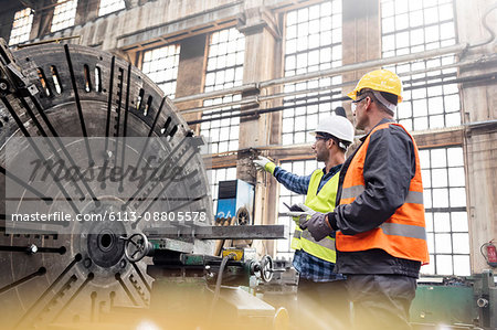 Steel workers talking in factory