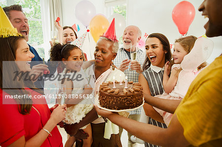 Multi-generation family celebrating birthday with chocolate cake