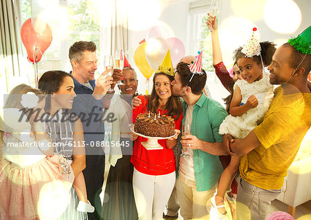 Multi-ethnic multi-generation family celebrating birthday with chocolate cake