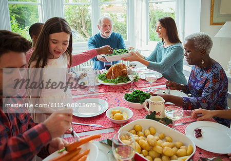Multi-generation family eating at Christmas dinner table