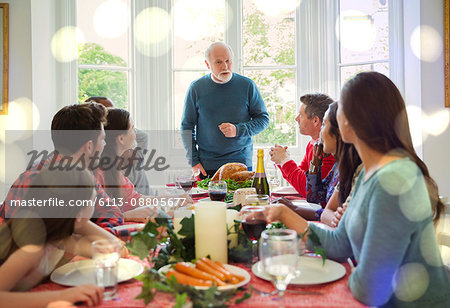 Grandfather preparing to carve Christmas turkey at dinner table