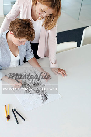 Female designers drawing sketch in conference room