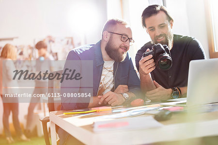 Photographer design professionals with SLR camera in office