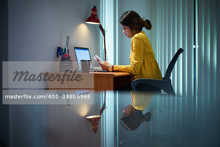 Young woman with laptop computer for homework. Tired hispanic girl and college education. Female student studying and using pc at home