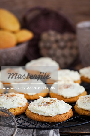 Homemade pumpkin spice cake cookies with glaze and cinnamon on cooling rack