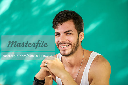 Real Cuban people and feelings, portrait of happy young hispanic man with beard from Havana, Cuba looking at camera and smiling