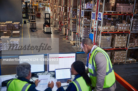 Managers working meeting at laptop and computers in distribution warehouse Managers working meeting at laptop and computers in distribution warehouse