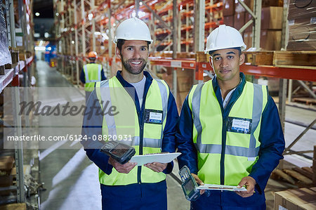 Portrait confident workers with scanners and clipboards in distribution warehouse