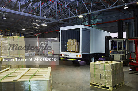 Trucks and cardboard box pallets at distribution warehouse loading dock