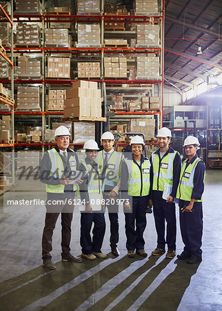 Portrait smiling manager and workers in distribution warehouse