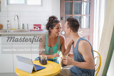 Young couple sharing coffee at kitchen table