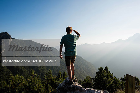 Rear view of man standing on mountain peak looking away, Passo Maniva, Italy