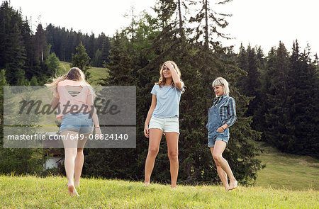 Three female adult friends playing in field, Sattelbergalm, Tirol, Austria
