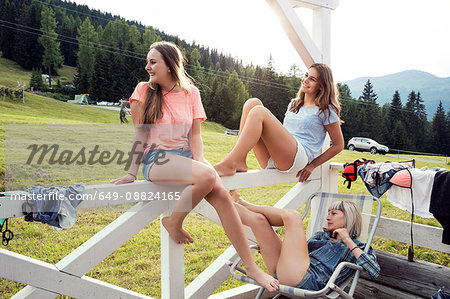 Three female adult friends looking from porch, Sattelbergalm, Tirol, Austria