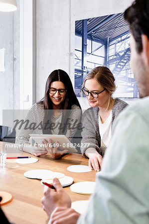 Colleagues at meeting in conference room using digital tablet