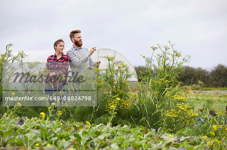 Couple on farmland using digital tablet