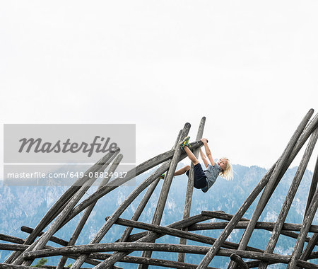 Boy climbing wooden structure in playground, Fuessen, Bavaria, Germany