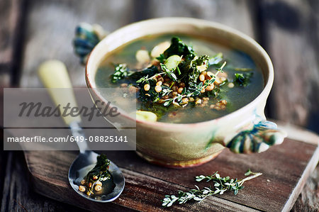 Bowl of broth on wooden cutting board