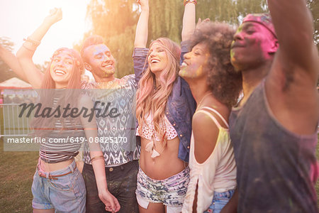 Group of friends at festival, covered in colourful powder paint