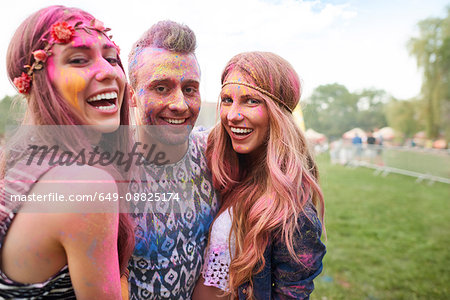 Group of friends at festival, covered in colourful powder paint